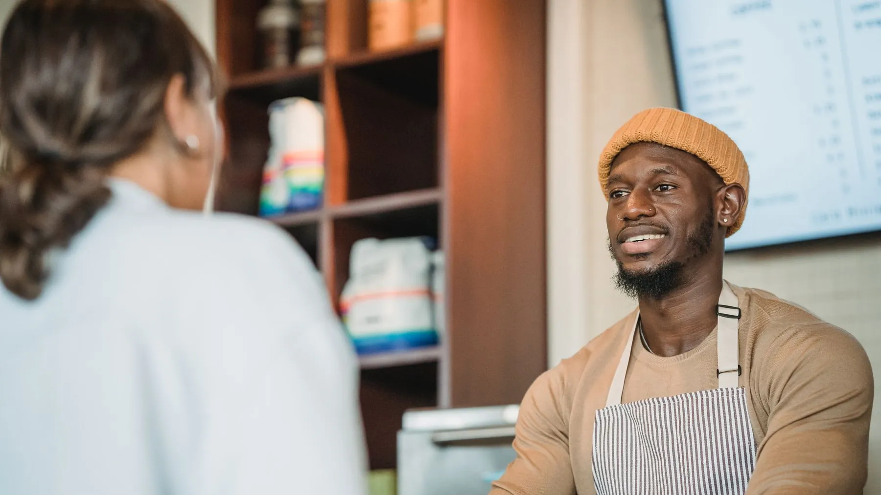 A person reviewing a restaurant website on a phone at a cafe counter